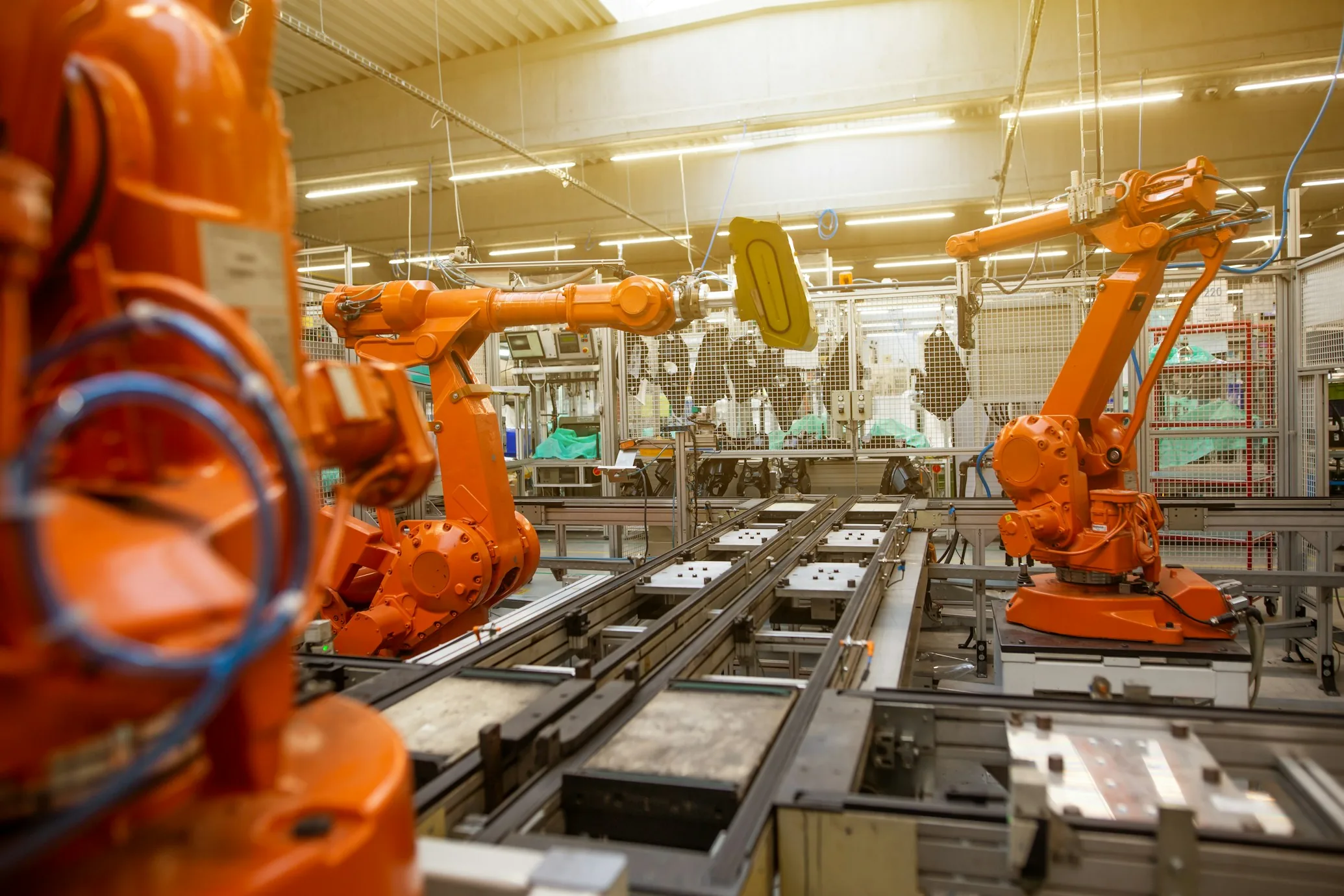 Lini produksi yang terdiri dari robot industri berwarna oranye, foto ilustrasi industri robotika